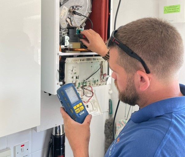 Guy adjusting a gas valve on a boiler