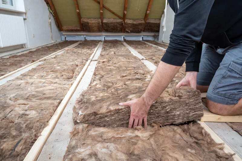 Stock image - man laying loft insulation